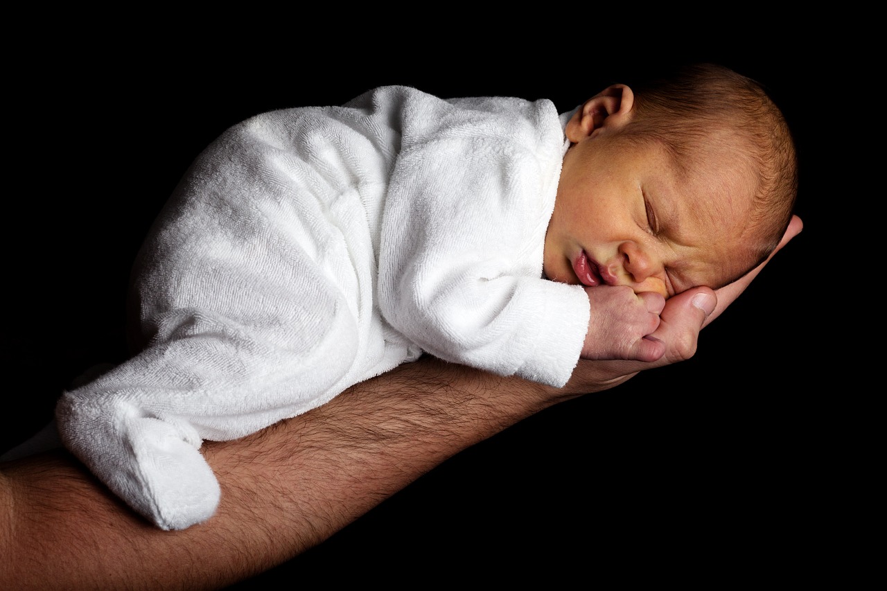 recien nacido durmiendo en el brazo de su padre