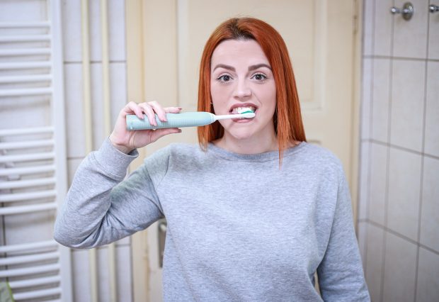Madre e hijo esperando 30 minutos antes de cepillarse tras el desayuno con zumo de naranja, cuidando el esmalte dental